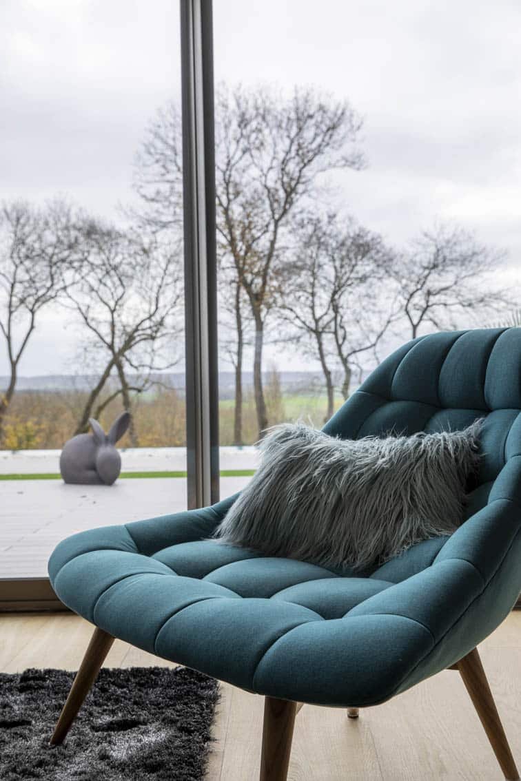 Detail of a blue lounge chair with a view to the outside, by Christiansen Design, Interior designer Yvelines and Decorator in Paris, Hauts de Seine, Provence