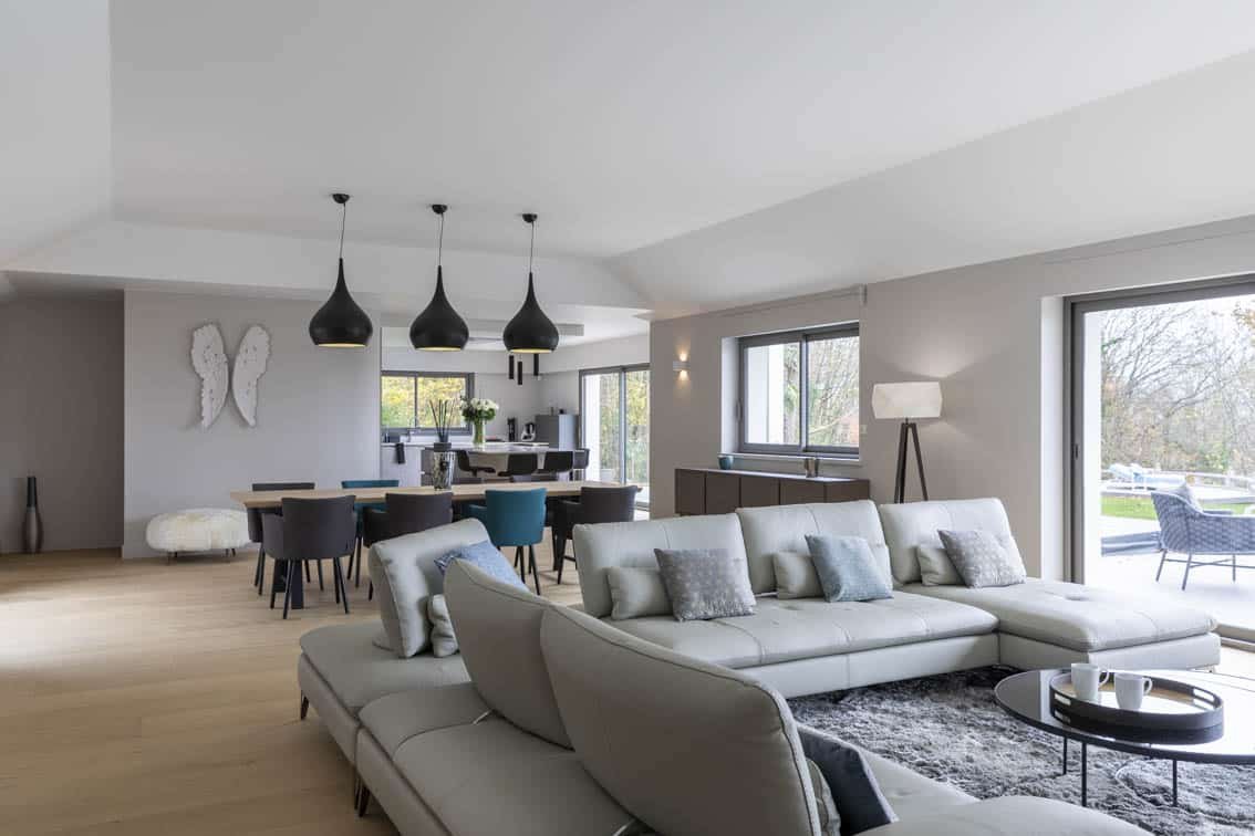 Overall view of the light gray living room, dining room and kitchen, by Christiansen Design, Interior designer in Yvelines and Decorator in Paris, Hauts de Seine, Provence
