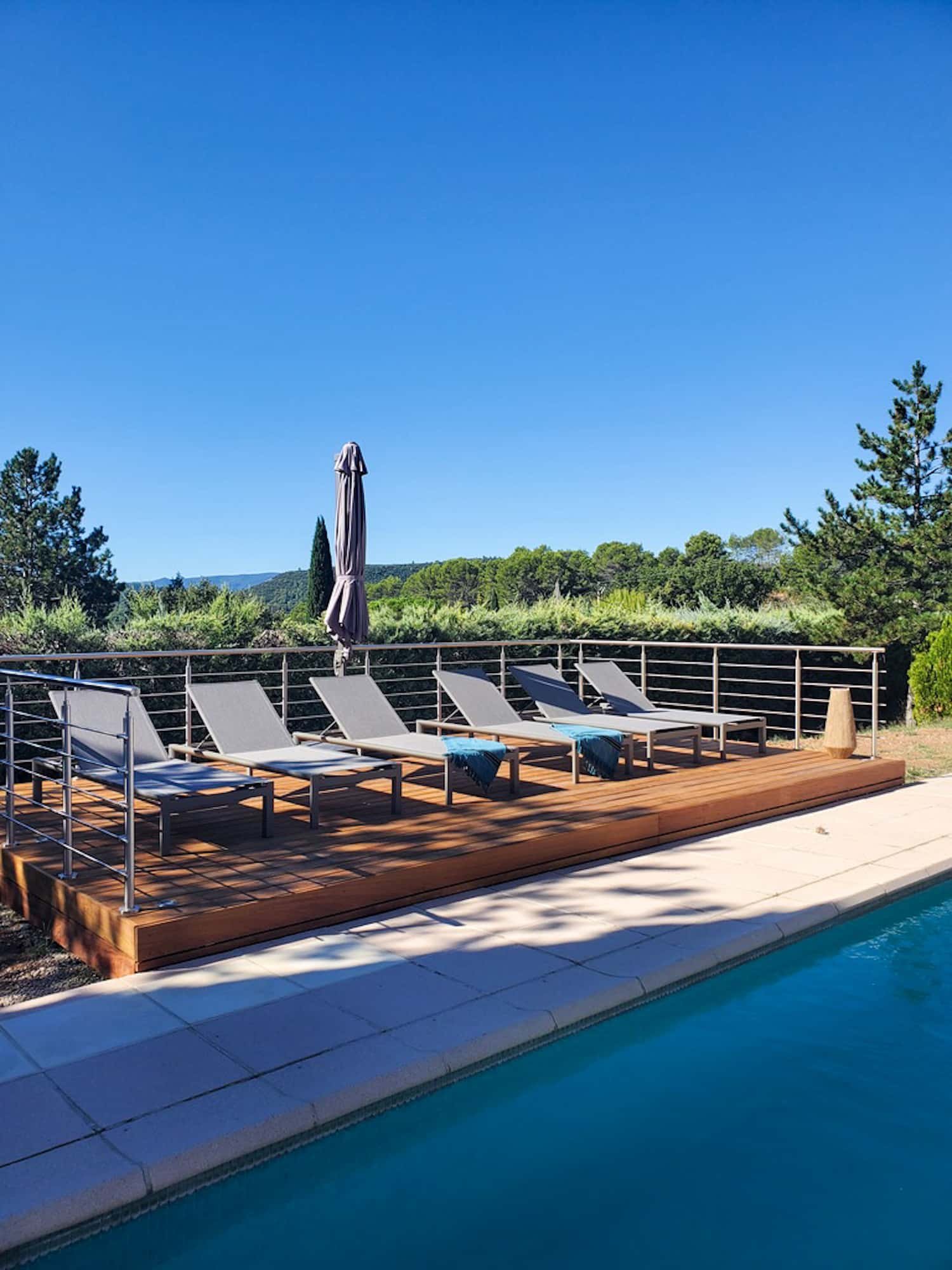 Terrasse au pied de la piscine avec ses transats-bain de soleil, by Christiansen Design, Architecte d'intérieur Yvelines et Décorateur à Paris, Hauts de Seine, Provence