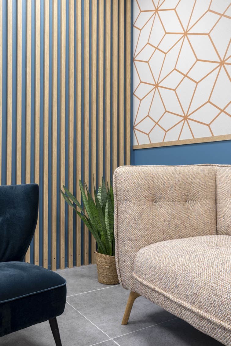 Details of the sofa and the claustra effect in oak on the wall in blue tones Christiansen Design, Interior designer Yvelines and Decorator in Paris, Hauts de Seine, Provence